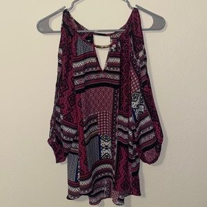 Pinkish/purple top cold shoulder long sleeve v neck has two slits.